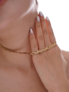 Close-up of triple-layered gold snake chain necklace showing flat woven metal texture