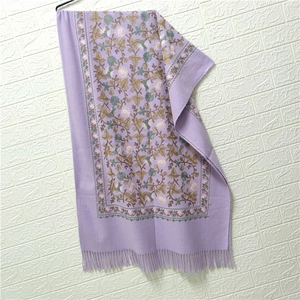 Close-up of purple cashmere-like scarf with intricate floral embroidery and tassel fringe