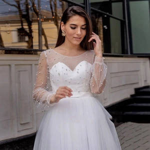 Robe de mariée de plage blanche avec manches longues en tulle et détails perlés élégants