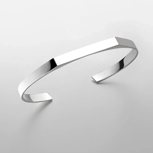 Detail of silver geometric steel bracelet with high-polished facets and modern open design