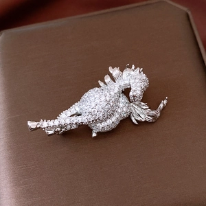 Macro detail of silver horse brooch with hand-set cubic zirconia on dark texture