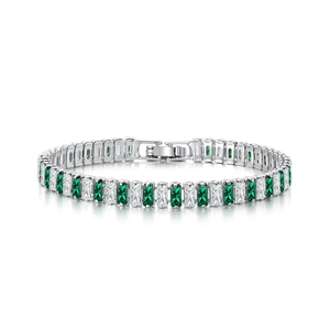 Macro view of silver tennis bracelet with alternating green and white emerald-cut zircons