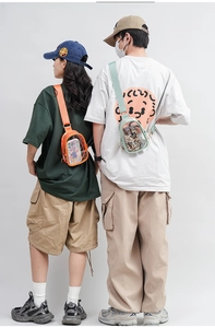 Rear view of models wearing orange and light green PVC crossbody bags with wide straps
