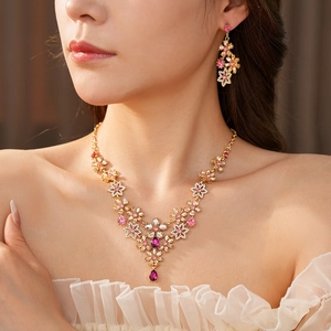 Detail of vintage flower jewelry set with pink and purple crystals on a female model