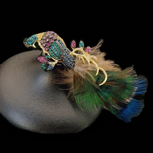 Macro detail of elegant peacock brooch with colorful crystals and natural feathers