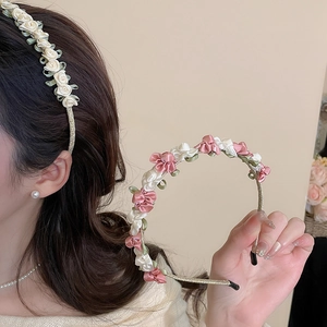 Close-up of handmade satin flower headbands on thin gold metal frames for elegant styling