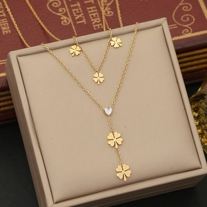 Detail view of gold clover and heart zircon pendant on Y-shaped stainless steel necklace
