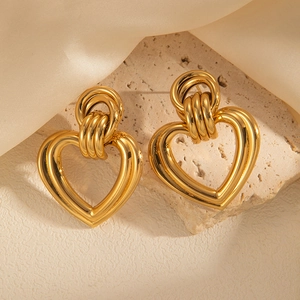 French vintage style gold layered heart drop earrings on a natural stone background