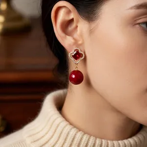 Vintage style gold flower earrings with red zircon and pearl beads worn by model