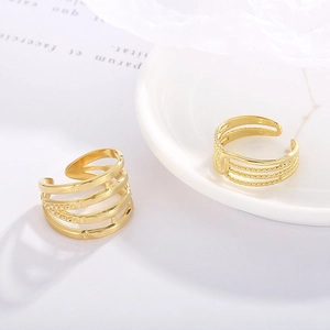 Close-up of golden multi-layer open rings with textured bead and line patterns