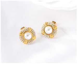 Detail of 18K gold plated stainless steel earring with inlaid white pearls on fabric