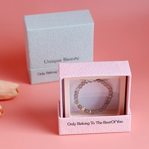 Pink drawer jewelry gift box with unique beauty text and beaded bracelet inside