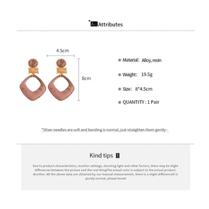 Detail showing marble resin geometric rhombus earrings with silver needle posts