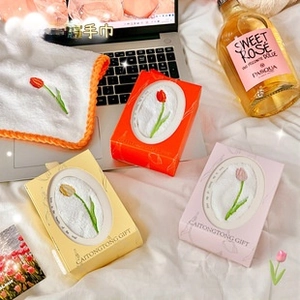 Exquisite gift box with tulip embroidered hand towels in warm home setting