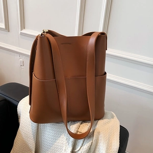 Braune Shopper-Tasche aus Leder mit großem Fassungsvermögen auf einer Strickdecke