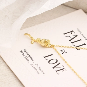Vue macro d'un collier pendentif rose en argent S925 doré avec carte romantique