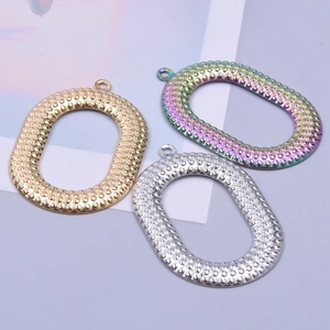 Three textured oval stainless steel pendants in gold, silver, and rainbow 18k plated finishes