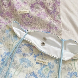 Detail of floral lace embroidery and magnetic closure on the elegant canvas tote bag