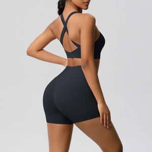 Detail view of black yoga set featuring cross-back sports bra and high-waisted shorts