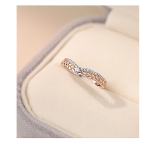 Macro shot of silver wheat ear ring with rose gold leaves and sparkling zircon stones