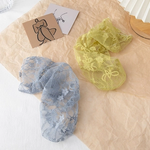 Detailed view of sheer floral lace mesh socks in pale blue and lemon yellow colors