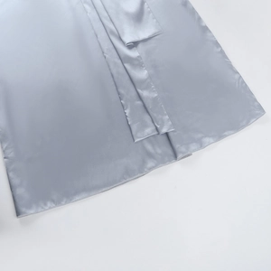 Gros plan détaillé de l'ourlet en satin bleu argenté et des coutures de cette robe élégante