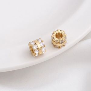 Macro shot of 14K gold plated wheel spacer beads with sparkling zircon inlay for DIY jewelry