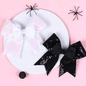 Close-up of sparkling sequin bow hair clips in white and black for Halloween styling