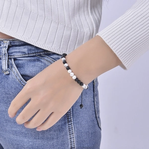 Détail du bracelet code Morse avec perles noires mates et turquoise blanche sur le poignet