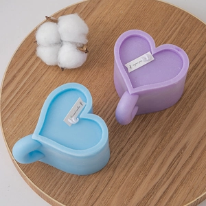 Creative heart-shaped cup scented candles in light blue and lavender on wood tray