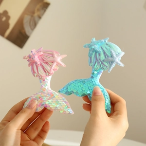 Detail of pink and blue sequin mermaid tail hair clips with starfish accents