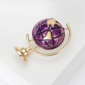 Detailed close-up of a globe brooch with gold metal frame and purple enamel coating