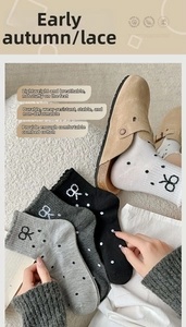 Close-up of polka dot lace socks in combed cotton paired with khaki suede mule clogs