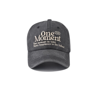 Detailed close-up of One Moment 3D embroidery on washed cotton charcoal baseball cap