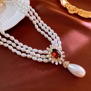 Collier de perles à trois rangs avec grande pierre rouge et perle en forme de goutte