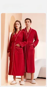Detail of red towel bathrobe showing soft terry texture and white piping trim