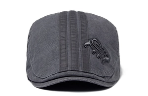 Detail of dark gray beret cap featuring vertical stripes and Gothic letter B embroidery