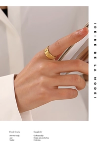Close-up of golden croissant dome ring with elegant spiral texture on model finger
