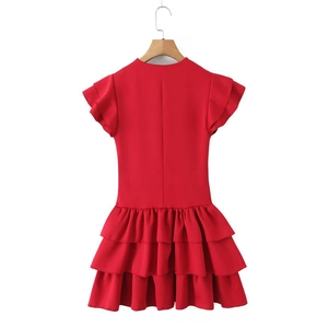 Detail of red sleeveless tiered ruffle dress with layered wave hem on white background