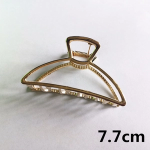 Detail of 7.7cm golden metal hair claw clip with elegant hollow structure and spring