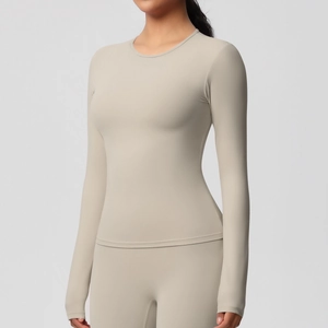 Haut de yoga beige clair à manches longues et coupe ajustée en tissu brossé extensible