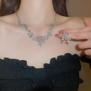 Macro shot of silver leaf and flower necklace and earrings set with sparkling crystals