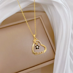 Gros plan du collier cœur doré avec pendentif football et cristaux sertis micro