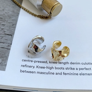Detail view of irregular S925 sterling silver ear cuffs on a minimalist magazine page