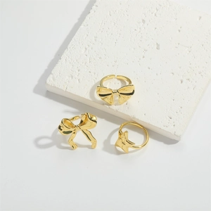 Adjustable gold butterfly and star open rings for women displayed on white pedestals