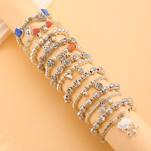 Detail of beaded bracelets with Buddha and koi charms on cylindrical jewelry displays