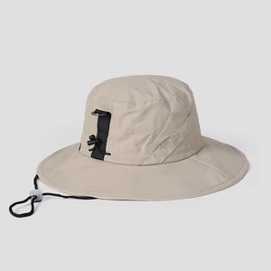 Detail of beige nylon sun hat showing ripstop fabric, windproof cord and side d-ring buckle