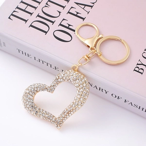 Detail of a heart-shaped gold keychain with sparkling crystals on a fashion book