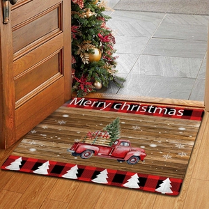 Cozy entryway scene with a red truck Christmas mat and a decorated tree in background
