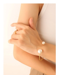 Detail of 18K gold-plated titanium bangle and ring set with elegant white imitation pearls